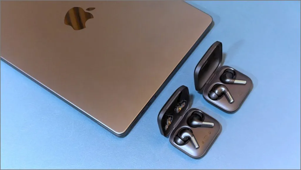 MacBook con dos auriculares verdaderamente inalámbricos