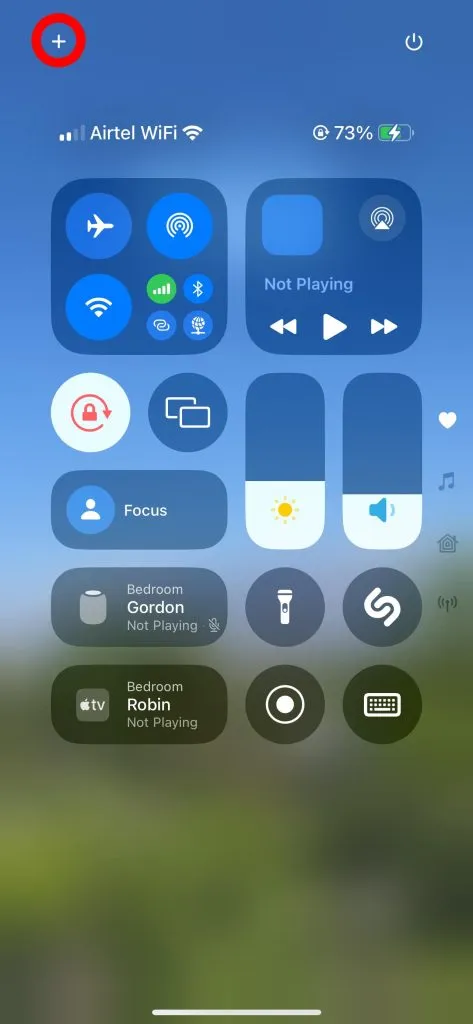 Tap the '+' button in the top-left corner of the Control Center on iPhone.