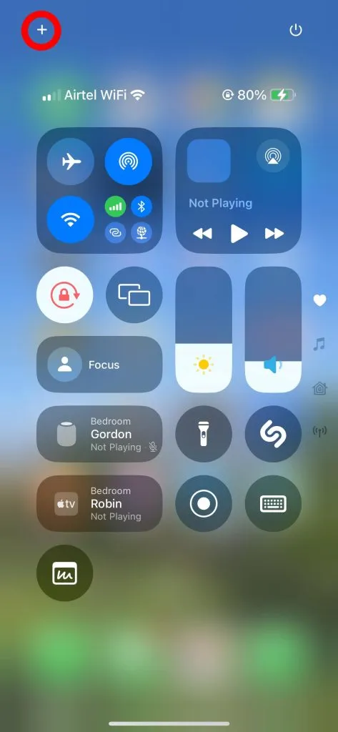 Tap the '+' icon in the top-right corner of the Control Center on iPhone