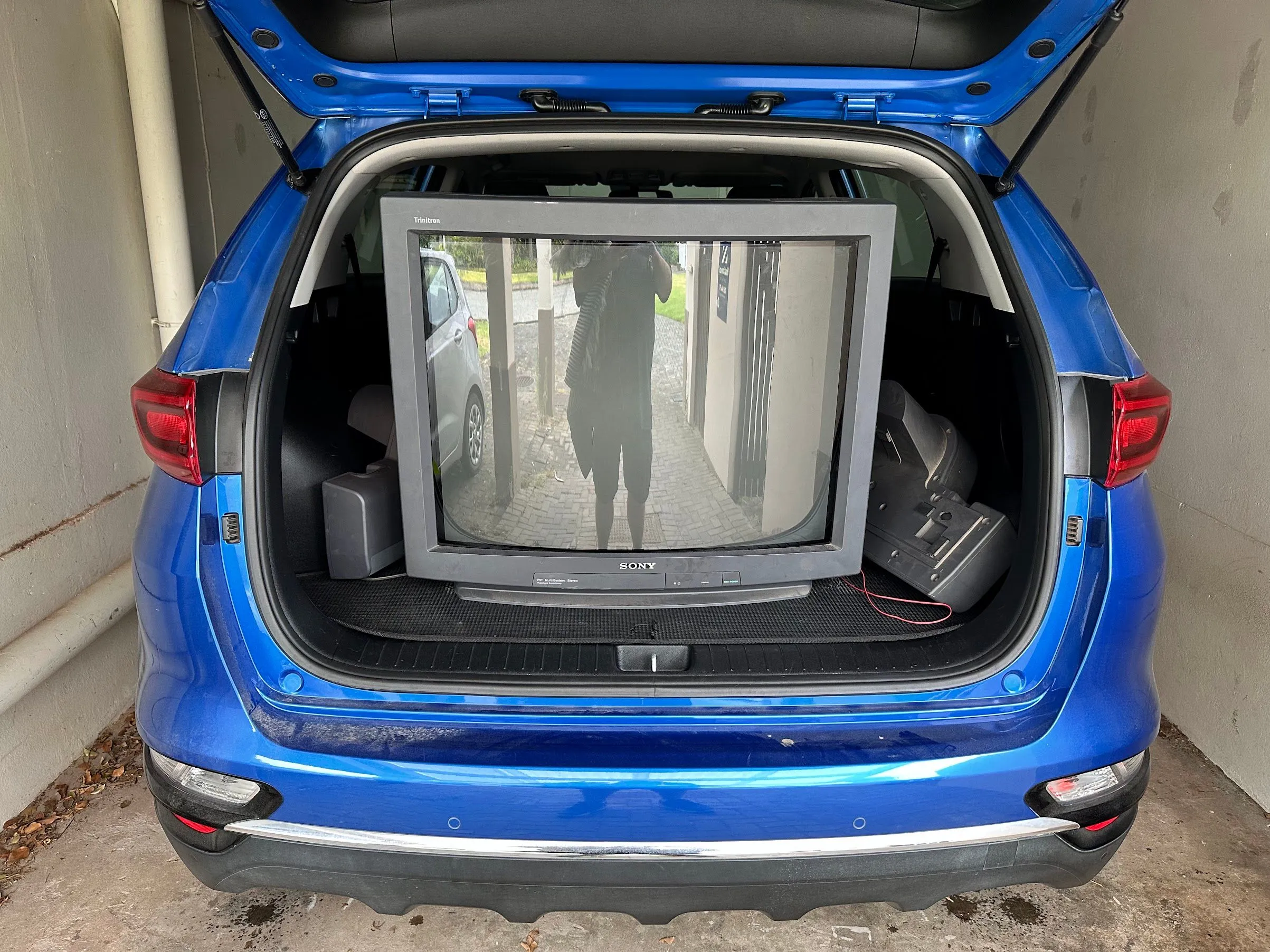 Een Sony CRT achterin een KIA Sportage.