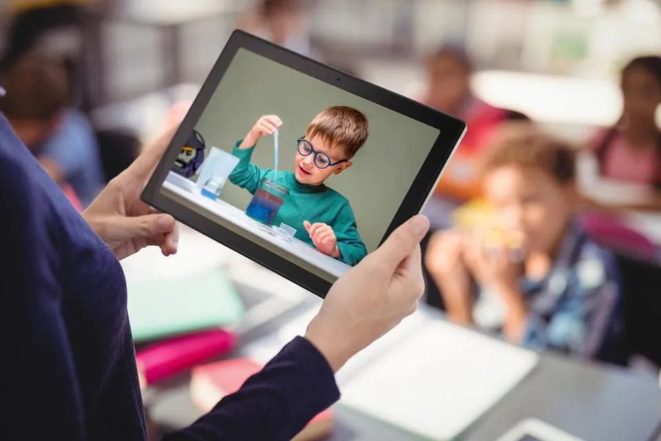 En kvinde, der holder en ASUS Chromebook-tablet i hånden, mens hun er i en klasse.