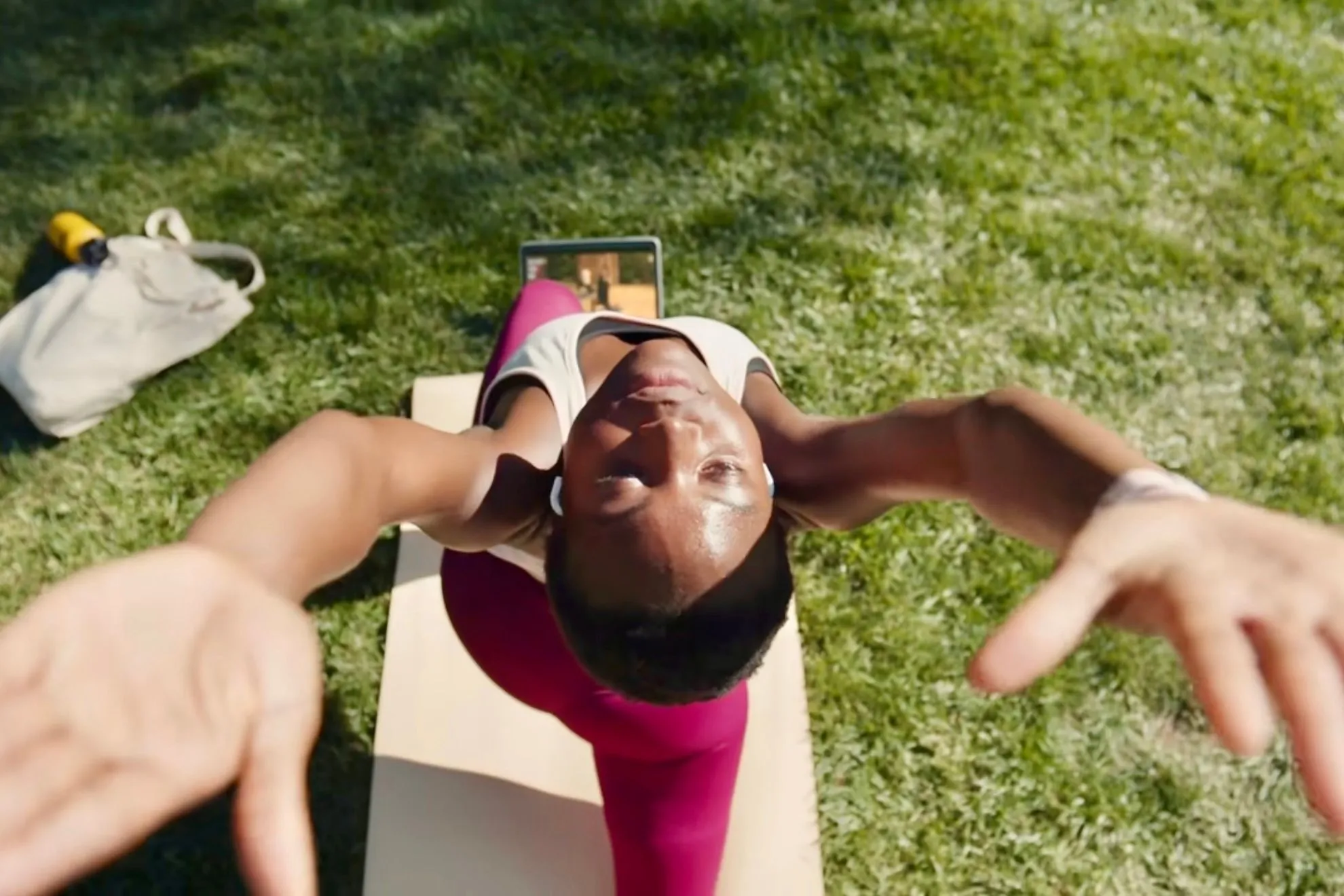 Individuelle Yoga-Übungen in einem Park mit Apple Fitness+.