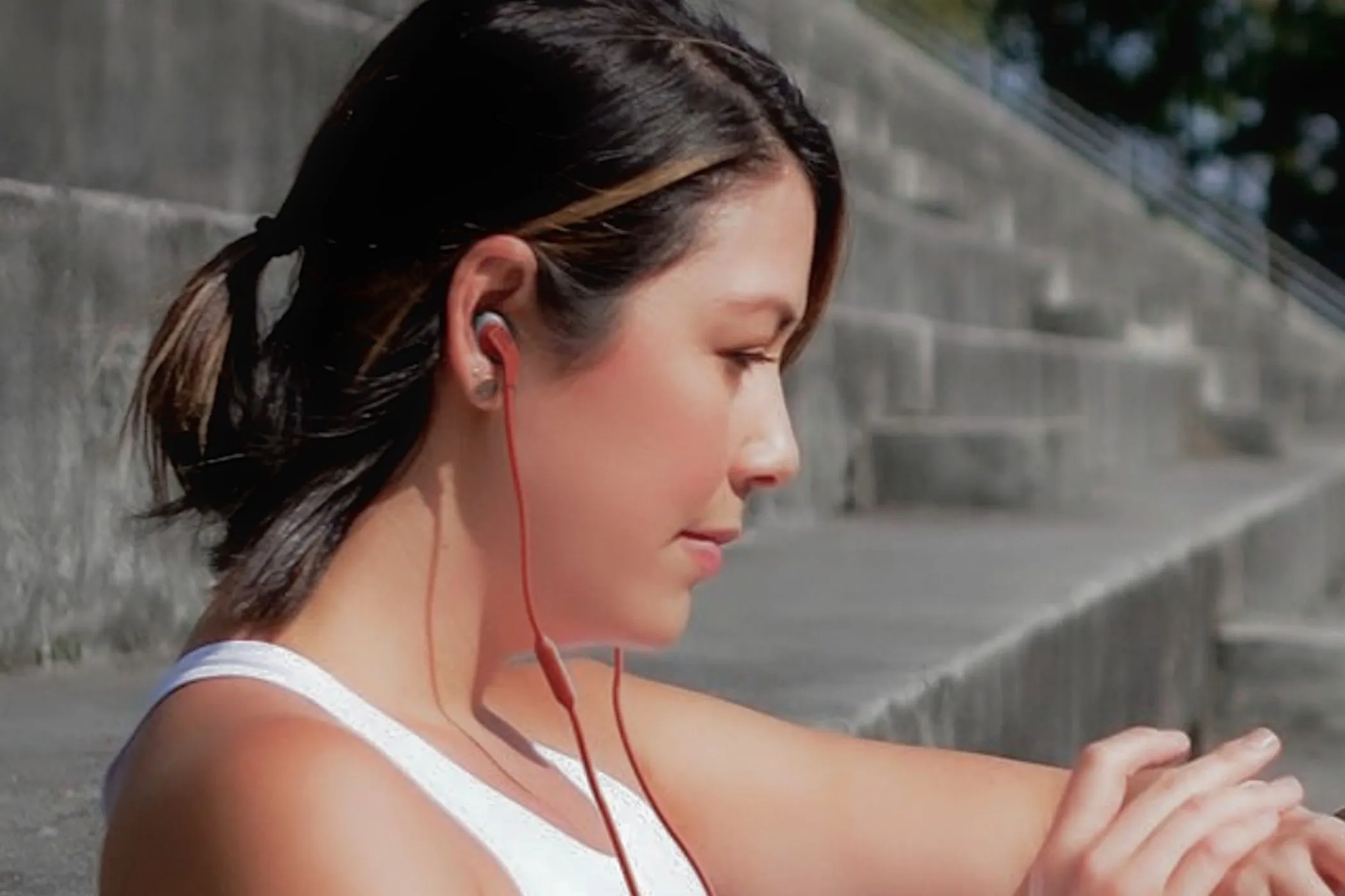 Uma mulher usando os fones de ouvido JBL Endurance Run 2 com fio durante um exercício.