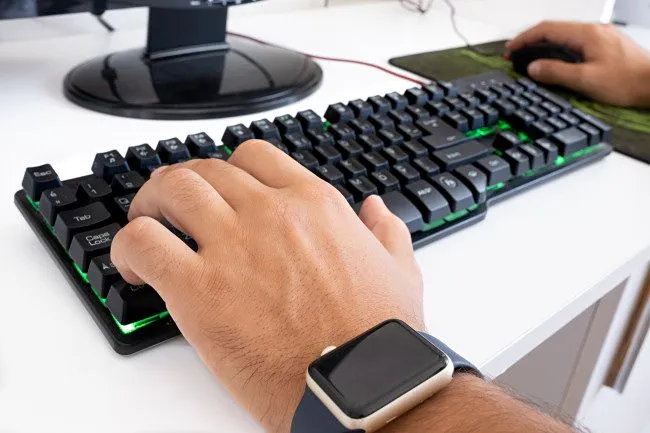 Um jogador de PC usando um teclado e mouse.